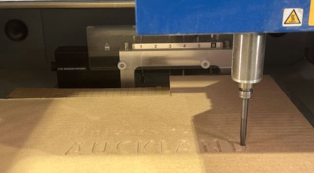 CNC machine carving UOA logo